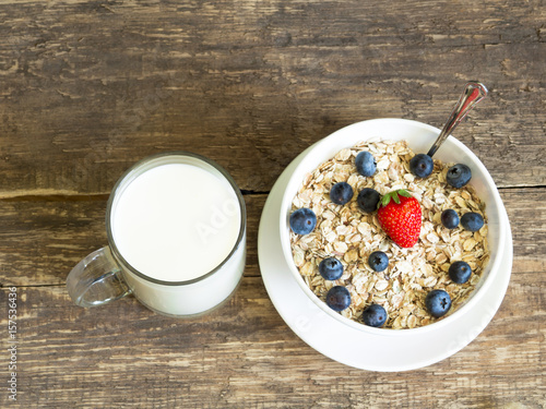 Oatmeal milk strawberry blueberry old board background