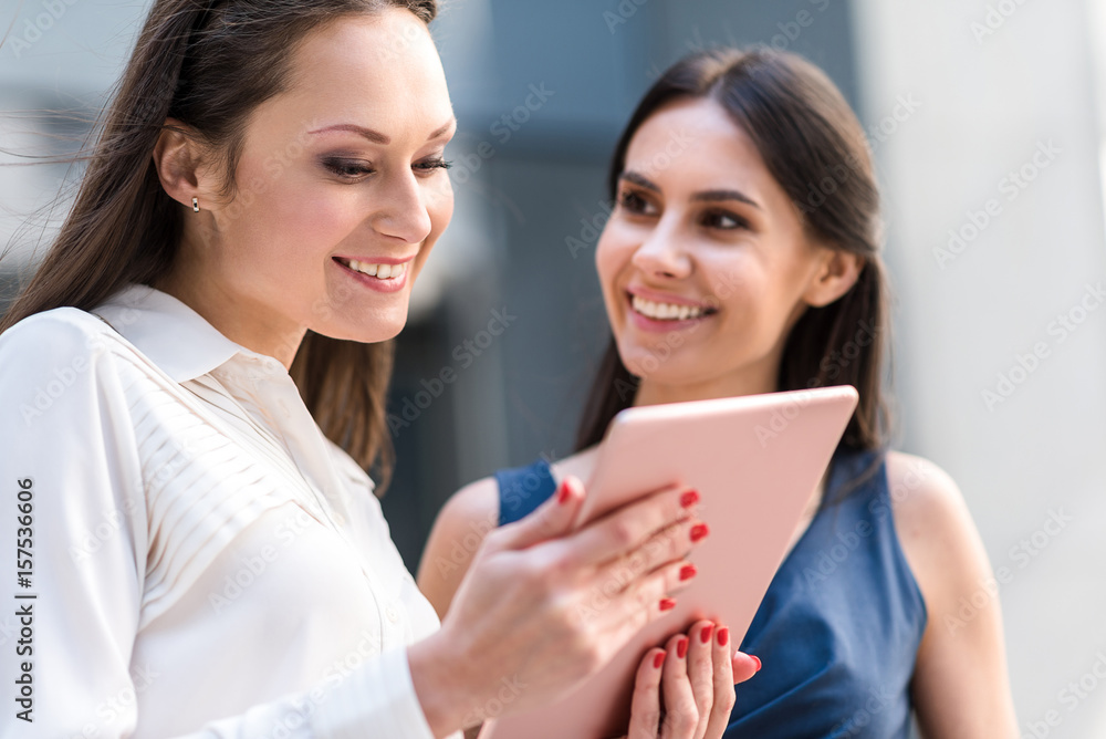 Happy colleagues looking at electronic tablet Happy colleagues looking at electronic tablet