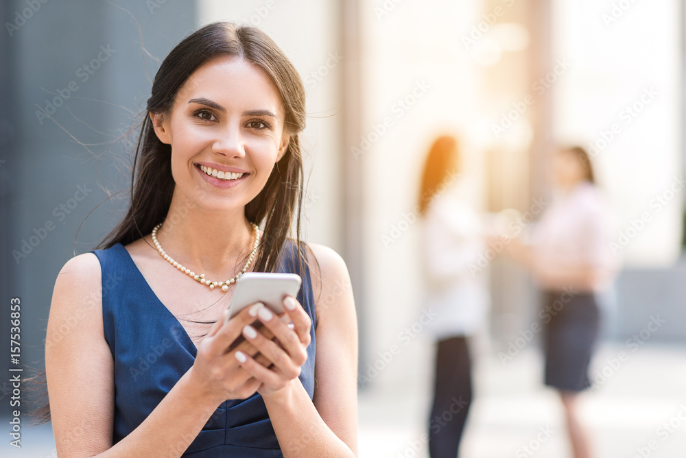 Cheerful female typing by mobile
