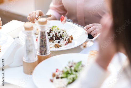 Hands of woman eating salad