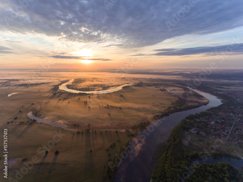 aerial view of river at sunrise, fly over morning mist on the river