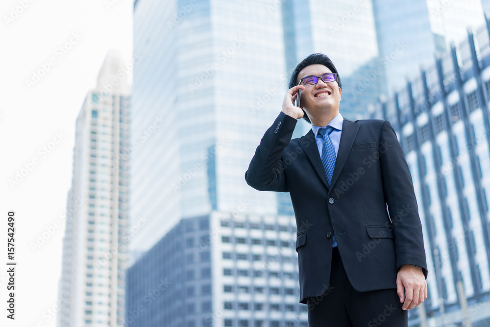 Young asian handsome businessman using smartphone with smiling Young asian handsome businessman using smartphone with smiling