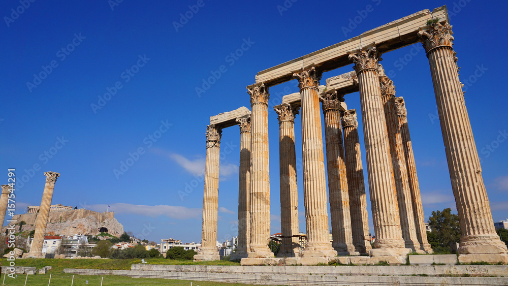 Photo of iconic pillars of Temple of Olympian Zeus with view to the Acropolis and the Parthenon, Athens historic center, Attica, Greece 