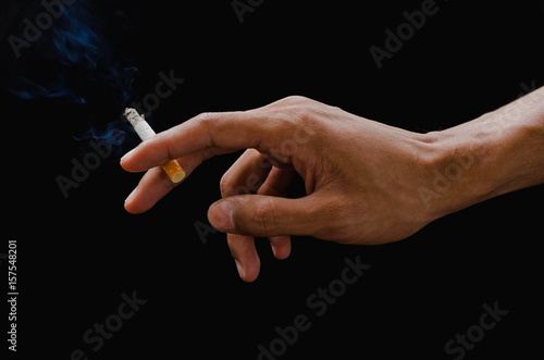 hand holding cigarette and smoke on black
