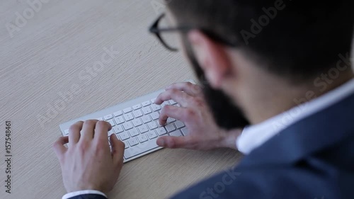 Businessman sitting in office and typing on keyboard photo