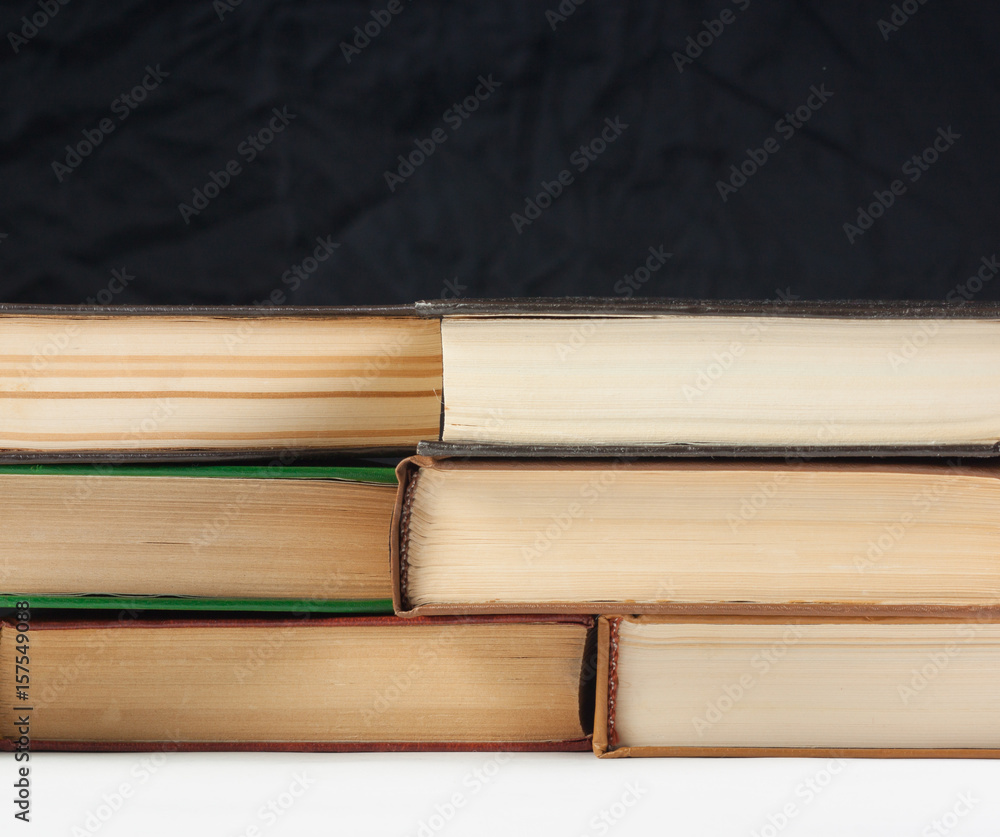 Old books on the table, on a black background, white table Old books on the table, on a black background, white table