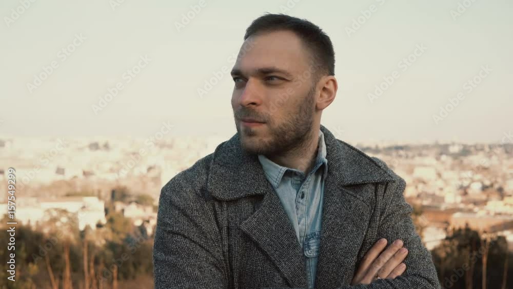 Young handsome man standing on the panoramic view of Rome, Italy and looking around. Serious male outside in sunny day. Young handsome man standing on the panoramic view of Rome, Italy and looking around. Serious male outside in sunny day.
