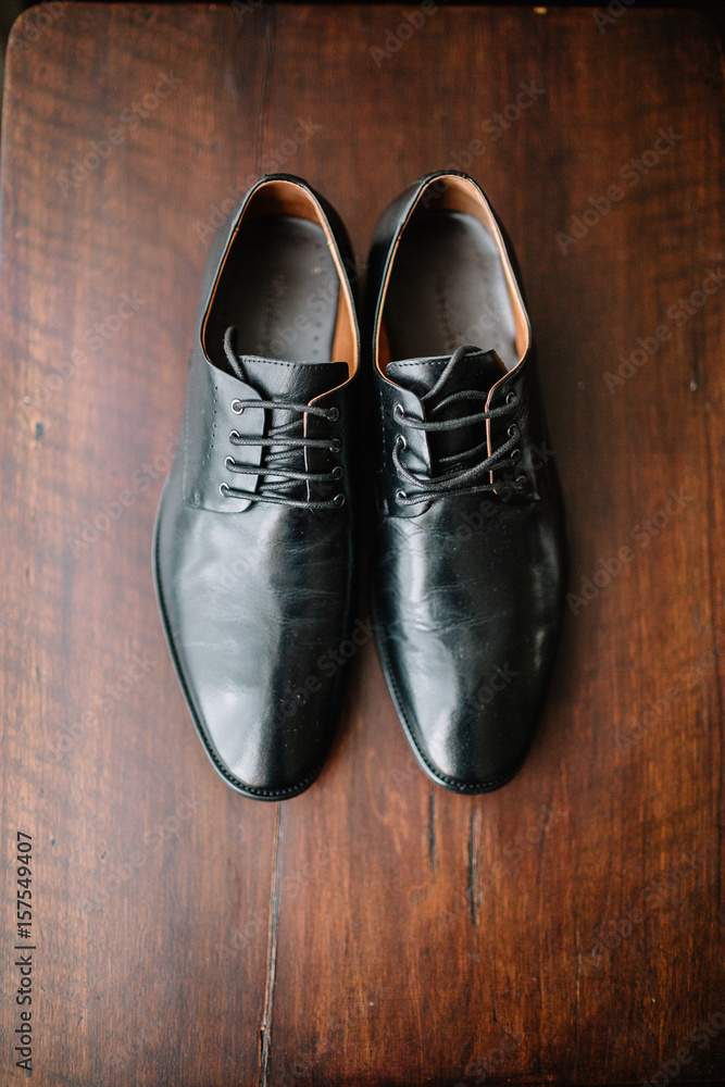 Black leather shoes stand on wooden floor Black leather shoes stand on wooden floor