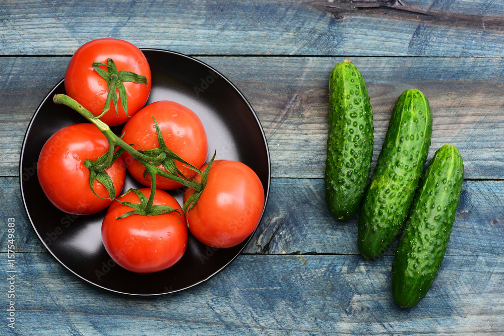 diet concept, cucumbers with tomato on plate on blue vintage diet concept, cucumbers with tomato on plate on blue vintage