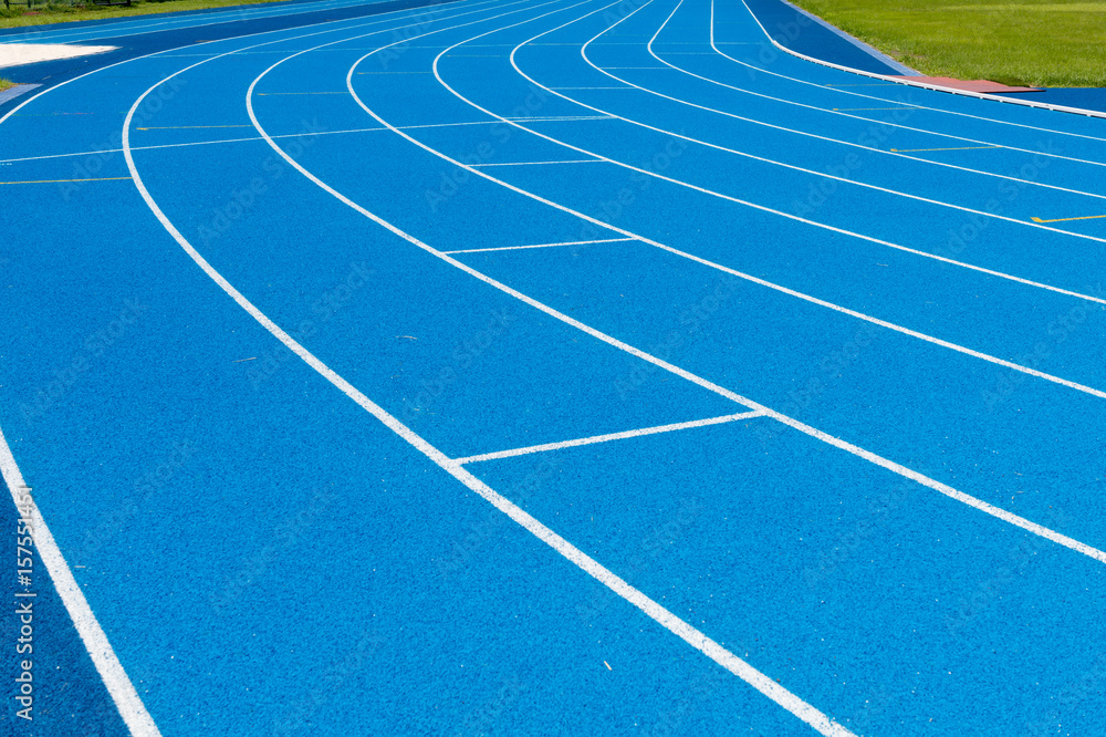 Blue Running track .Lanes of blue running track.Running track with blue asphalt and white markings in outdoor stadium.selective focus.