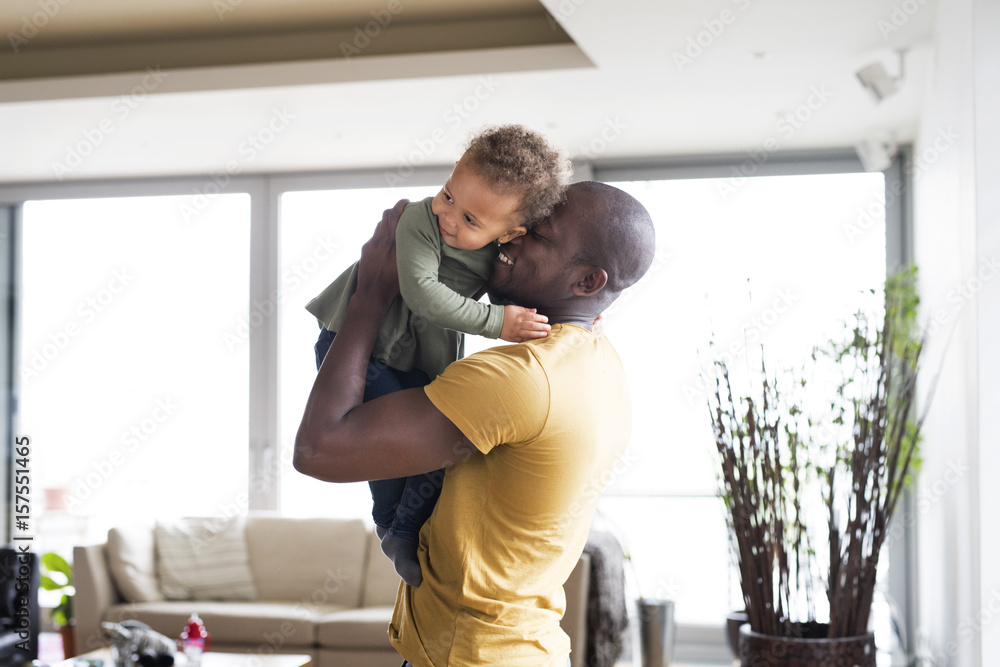 Fototapeta premium Young afro-american father with his little daughter at home.