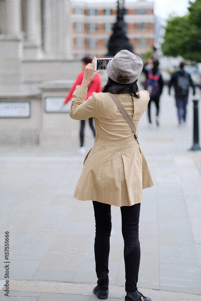 A woman takes pictures of the sights of the city. London, Great Britain.