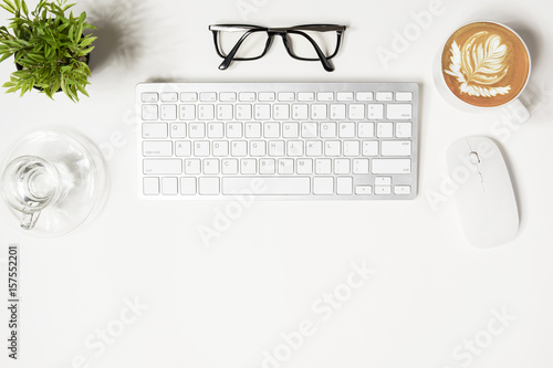 White hipster office desk with computer gadgets and supplies. Top view with copy space, flat lay.