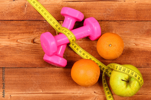 weight loss concept, dumbbells weight with measuring tape, fruit