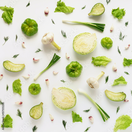Fresh vegetables on a white background. Vegetable food background. Pattern of cabbage, radish, lettuce, green pepper, young garlic, sorrel. Top view.