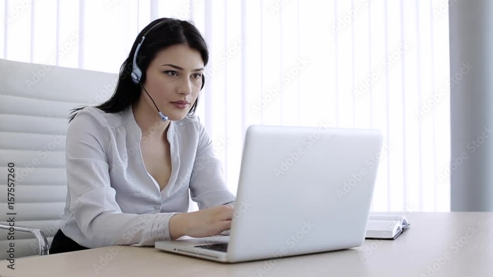 Beautiful woman talking with someone using headset in call center Beautiful woman talking with someone using headset in call center