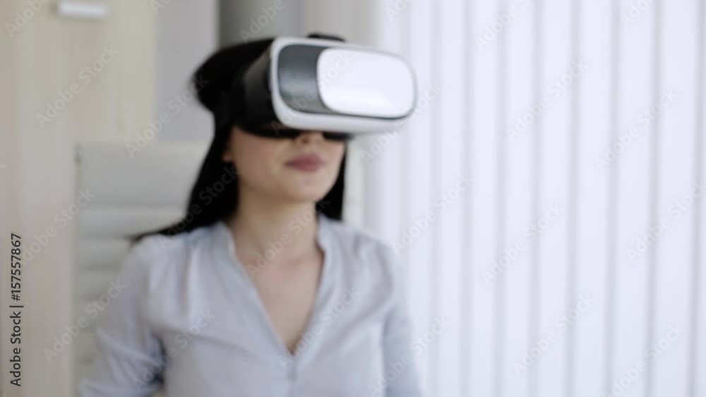 Attractive woman in office with virtual reallity glasses working and moving her hands Attractive woman in office with virtual reallity glasses working and moving her hands