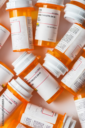A bunch of prescription pill bottles grouped on a table with white background