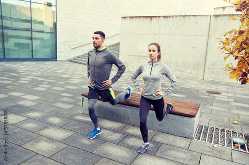 couple doing lunge exercise on city street