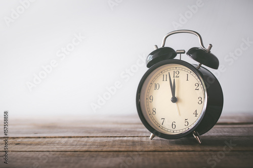 retro alarm clock on wood table with grunge background time for lunch concept.