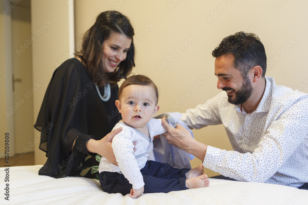 couple of mom and dad having their baby get dressed