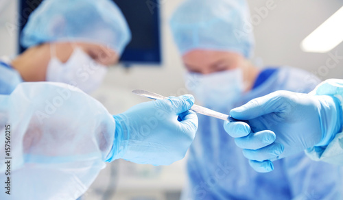 Obraz na plátně close up of hands with scalpel at operation