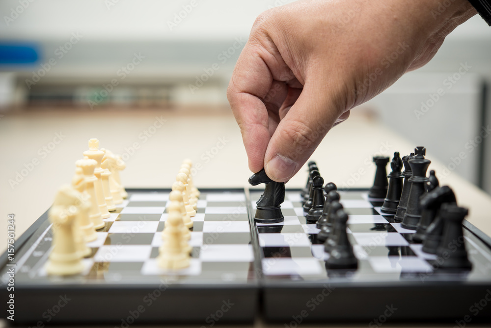 Hand of business man is playing chess board Hand of business man is playing chess board