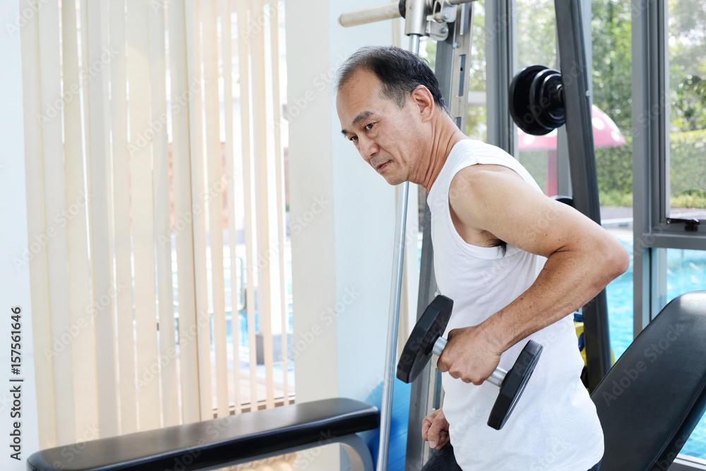 Senior Sport Man Lifting Dumbbells in Weight Training Fitness - Sport and Lifestyle Concept Senior Sport Man Lifting Dumbbells in Weight Training Fitness - Sport and Lifestyle Concept