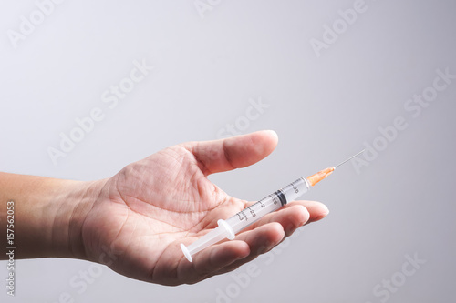 Hand holding syringe as drug patient