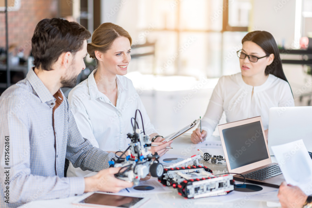 Fototapeta premium Cheerful colleagues creating new devices
