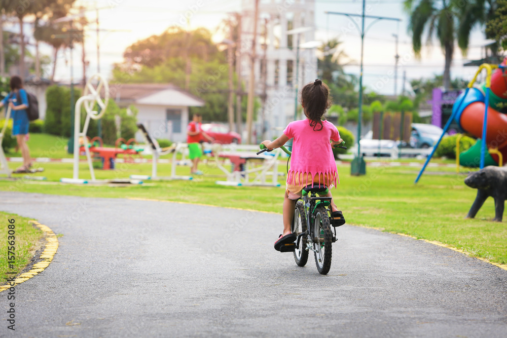 Little girl with her bike in the park.