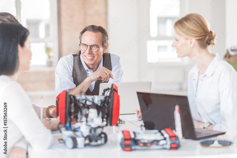 Obraz premium Positive engineers creating robot in office