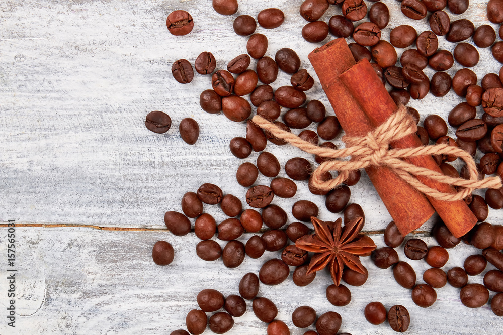 Coffee grain on wooden background. Cinnamon and badian on table. Coffee pleases the eye.