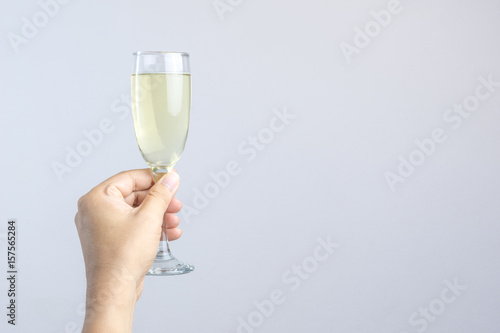 Hand holding glass of champagne for celebration on white backgroun