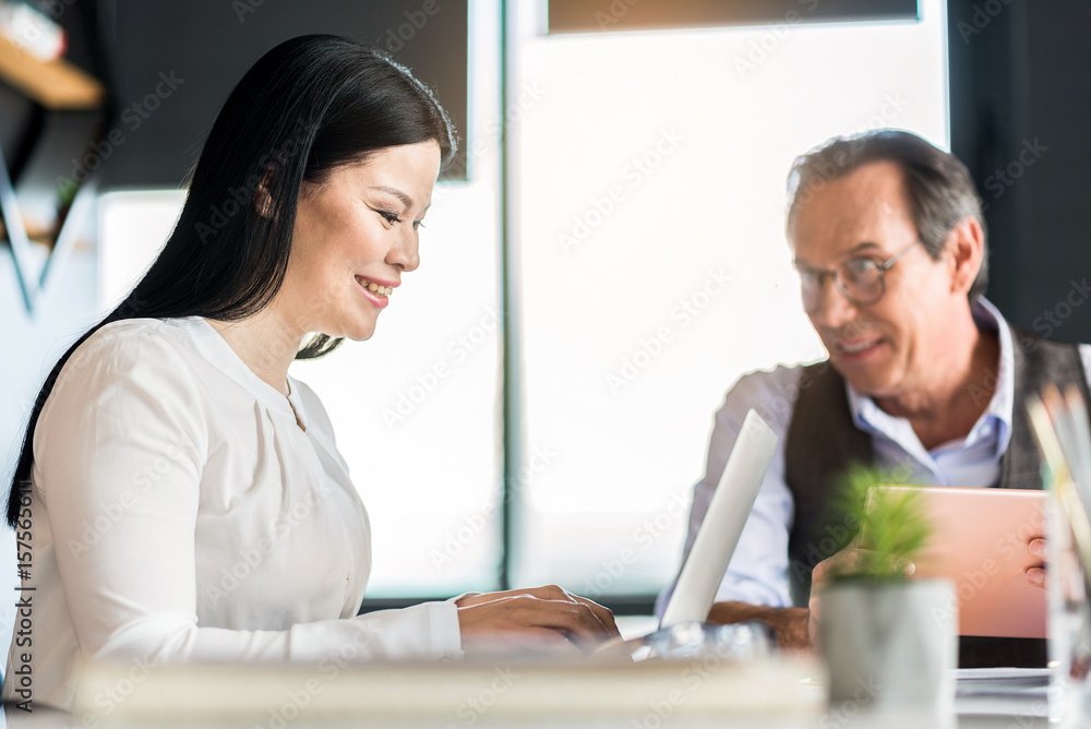 Cheerful confident employees laboring in office with joy Cheerful confident employees laboring in office with joy