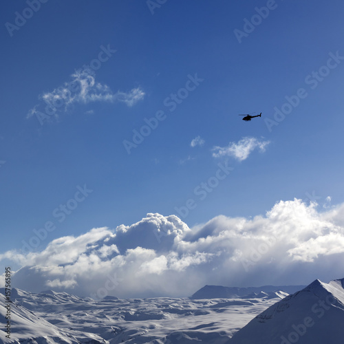 Helicopter above snowy plateau and sunny sky © BSANI