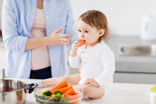 happy mother and baby eating at home kitchen