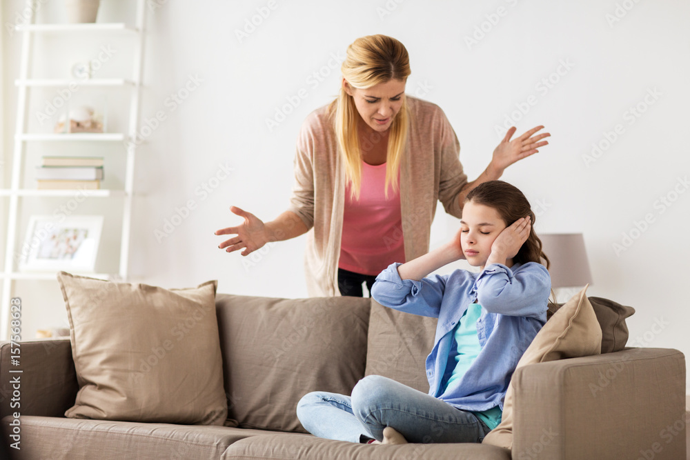 girl closing ears to not hear angry mother at home girl closing ears to not hear angry mother at home