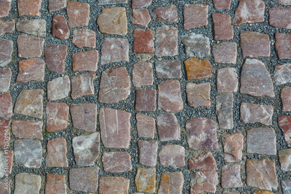 Stone granite cobblestoned pavement background or texture. Abstract background of old cobblestone pavement close-up in Prague Stone granite cobblestoned pavement background or texture. Abstract background of old cobblestone pavement close-up in Prague
