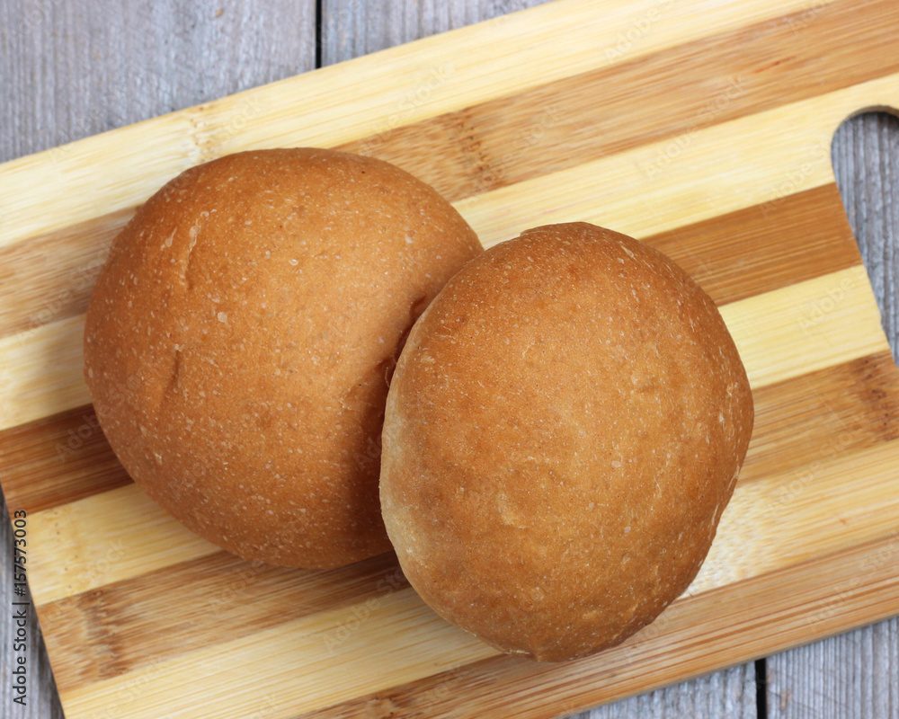 Two rolls on a cutting Board. Wheat bread. Two rolls on a cutting Board. Wheat bread.