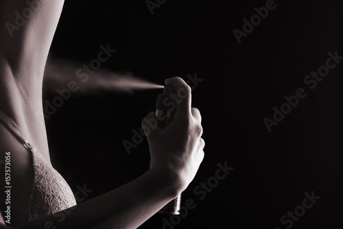 A woman sprays deodorant