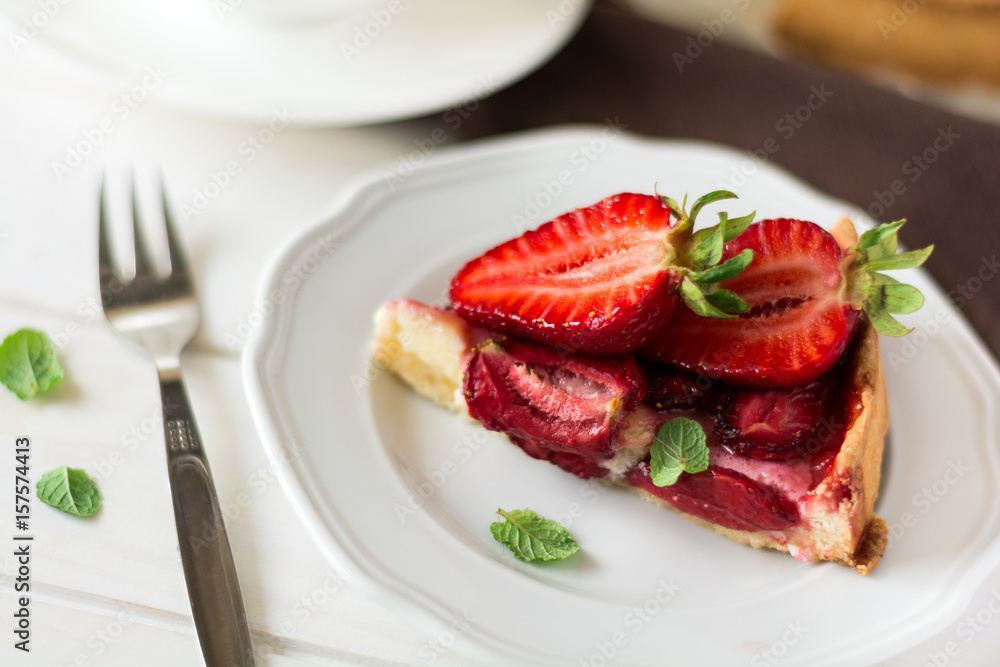 Fresh homemade tart with ricotta cheese and strawberries on white wooden table. Selective focus