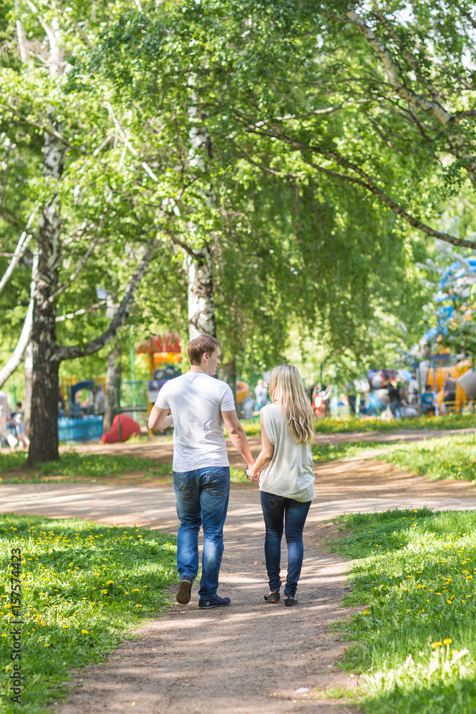 Romantic happy couple in the summer park. Rear view Romantic happy couple in the summer park. Rear view