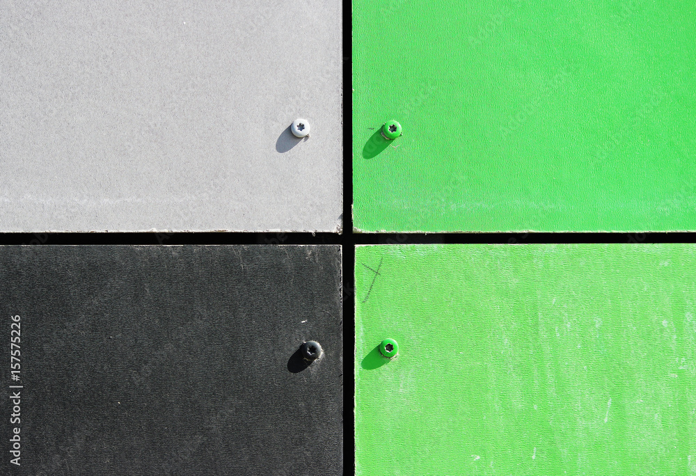 The wall of the house, trimmed with colorful panels, painted in bright colors. Green, grey and black