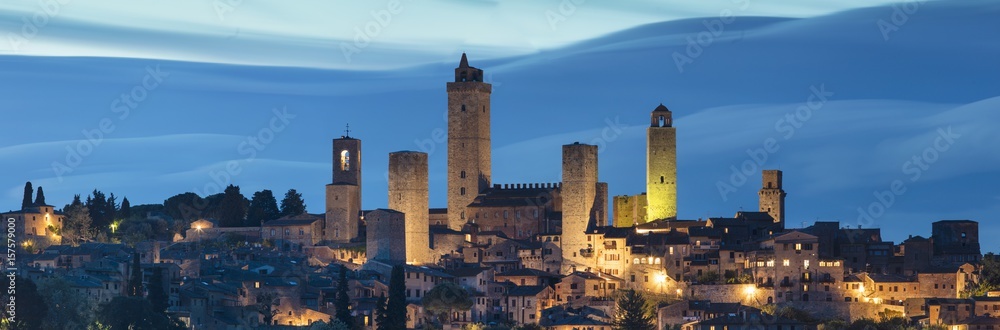 Old city in twilight time with blue moving clouds in Italy