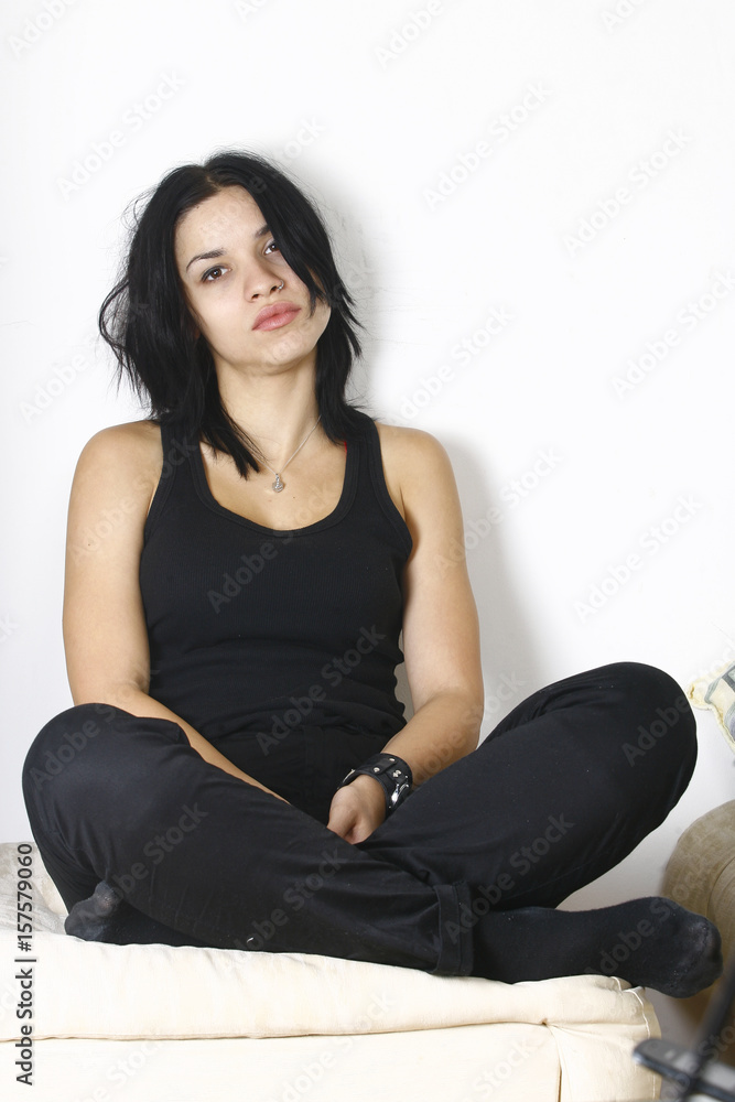 Young attractive brunette sitting on sofa