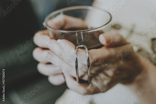 hands of woman with black coffee mug
