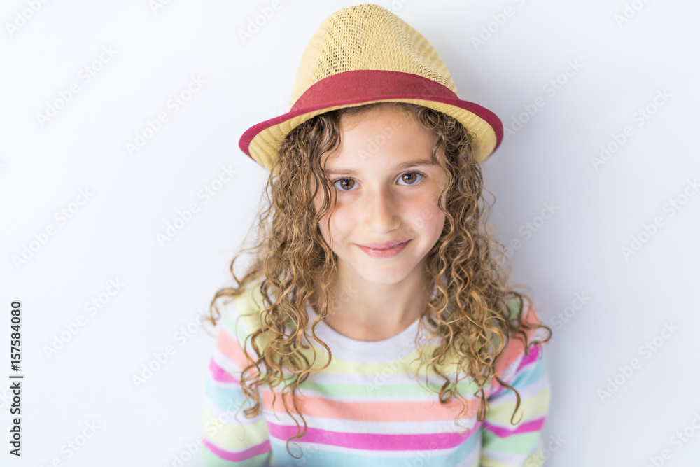 Portrait of 9 years old girl with curly hair, isolated on gray Portrait of 9 years old girl with curly hair, isolated on gray