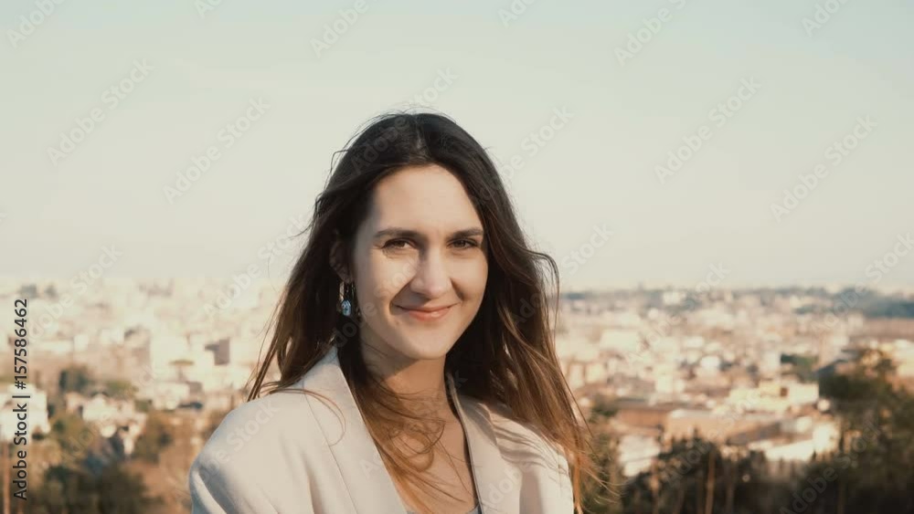 Portrait of happy smiling woman standing against the panorama of Rome, Italy. Female looking at camera, enjoying the day Portrait of happy smiling woman standing against the panorama of Rome, Italy. Female looking at camera, enjoying the day
