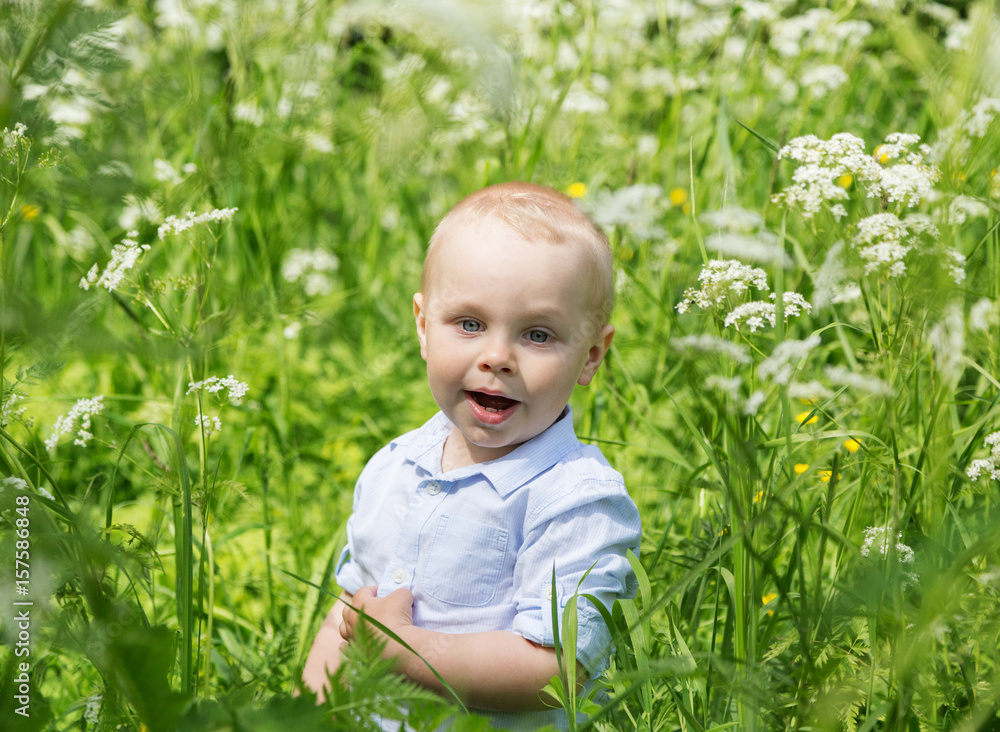 Cute joyful little boy running in the meadow in the tall grass Cute joyful little boy running in the meadow in the tall grass